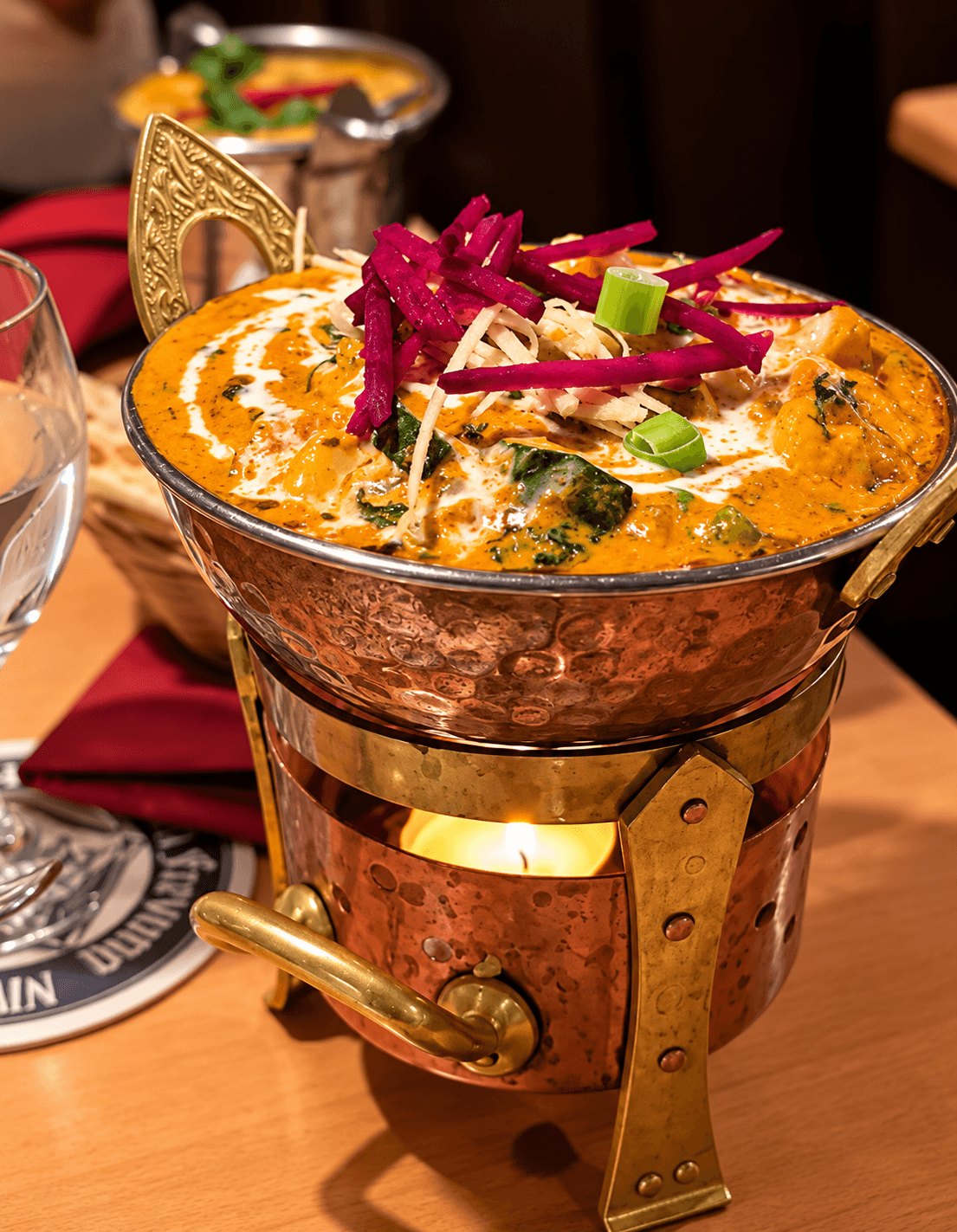 Cremiges Curry im Kupfertopf über einem Teelicht-Stövchen